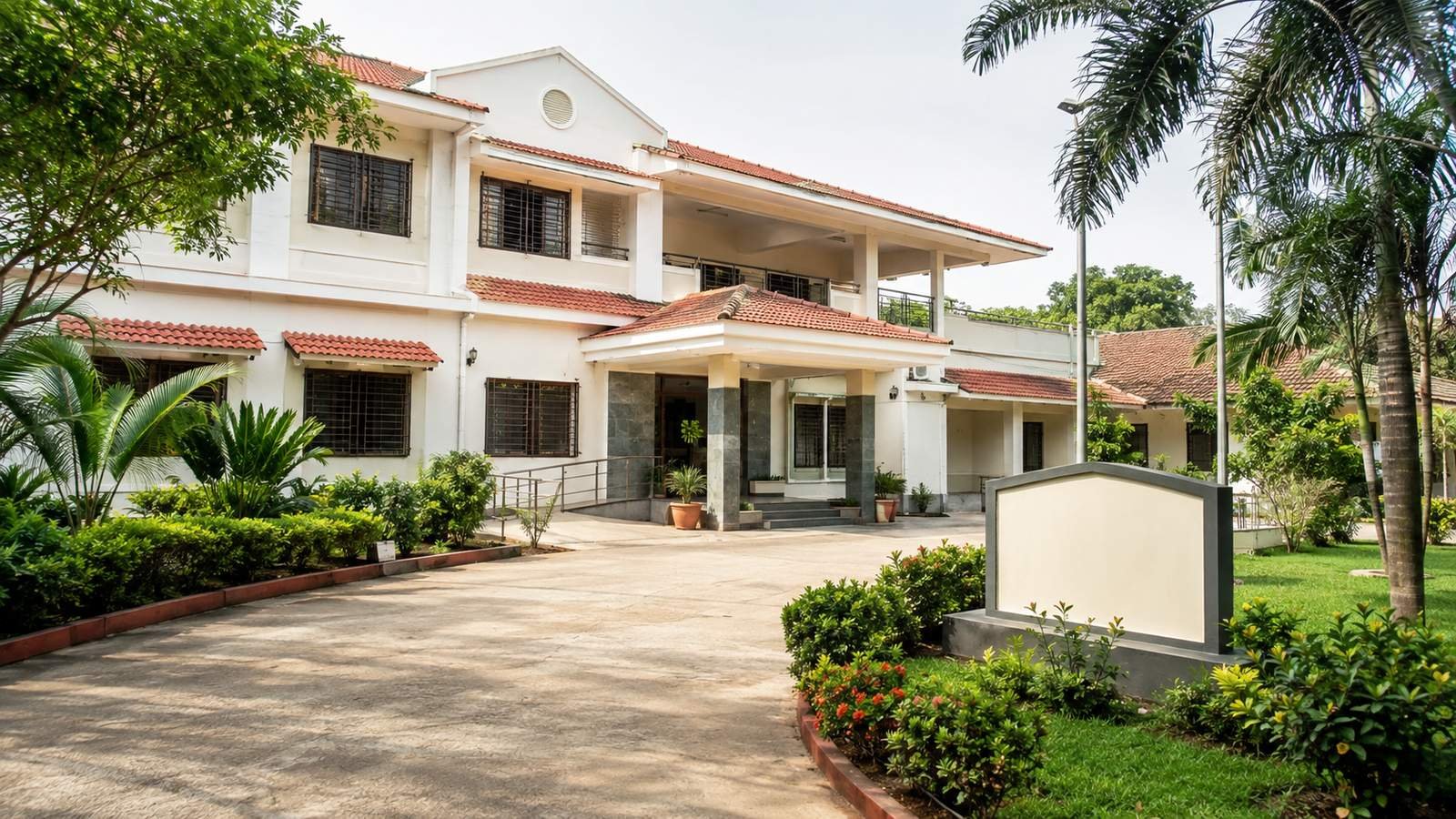 The exterior of a modest, professional South Indian rehabilitation centre building — clean and trustworthy